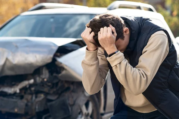 Een ongeluk op de snelweg. De man greep zijn hoofd, realiseerde zich dat de schade ernstig is, de auto is niet meer te repareren. Stockfoto