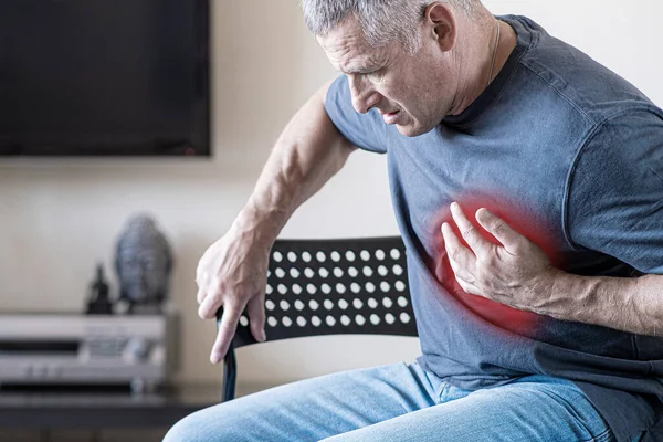 Una persona experimenta dolor en el pecho causado por un ataque al corazón. Enfermedad cardíaca. Angina de pecho. El concepto de seguro de salud para las personas mayores. —  Fotos de Stock