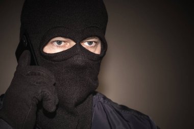 Yüzünde kar maskesi olan siyah elbiseli bir şantajcı. Zalim bir dolandırıcı cep telefonu kullanır. Mobil raket. Banka hesaplı telefon dolandırıcılığı.