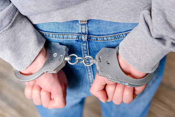 A criminal has been detained. Hands are wound back, handcuffs are put on to prevent aggression. Royalty Free Stock Images