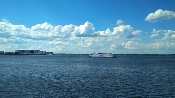 a small motor ship sails along the Volga River