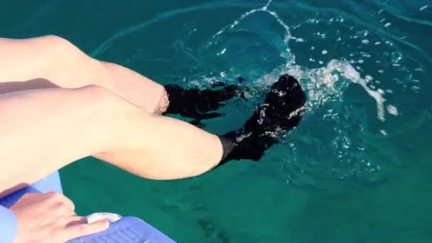 Männerfüße in schwarzen Socken planschen im Meerwasser, der Mittelplan. Freizeit- und Downshifting-Konzept. 4k — Stockvideo