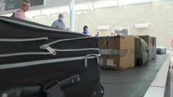 Cintura bagagli dell'aeroporto. Reclamo bagagli. Vista dal basso. Le persone sullo sfondo stanno aspettando i loro bagagli. 4k, rallenta. Tirana, Albania, 23 luglio 2021 — Video Stock