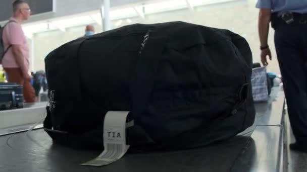 Пояс багажу в аеропорту. Заява багажу. Нижній вигляд. Люди на задньому плані чекають на свій багаж. 4k, повільний рух. Тирана (Албанія) 23 липня 2021 року — стокове відео