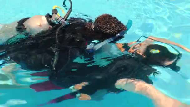 在游泳池里潜水俯瞰教练在水肺齿轮与氧气筒背面的训练客户潜水。学习潜水的过程。埃及，沙姆沙伊赫，2021年4月22日 — 图库视频影像