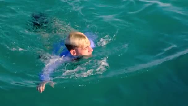 Смішний чоловік у сорочці і краватці плаває в морі в сонячний день. Повільний рух, 4k — стокове відео