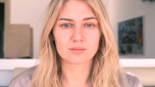 Junge schöne blauäugige Blondine ohne Make-up blickt in die Kamera. Morgenporträt eines Mädchens. Zeitlupe, 4k — Stockvideo