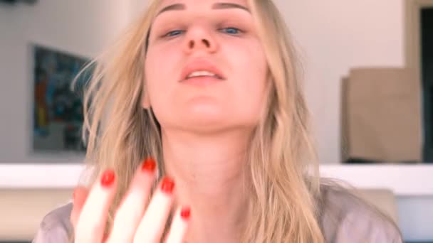 Здоровая молодая голубоглазый блондинка наносит питательный крем для лица. Уход за собой, косметические процедуры. 4k, slow motion — стоковое видео