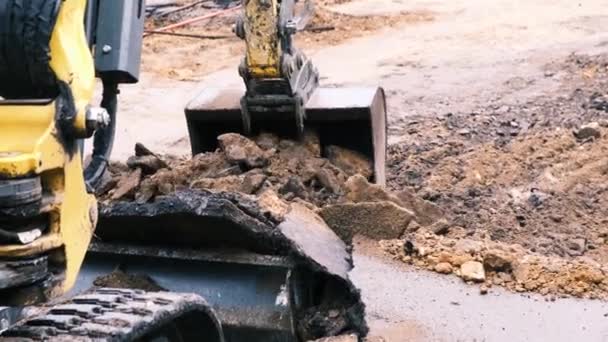 Az ásó vödör törött aszfaltot és földet jelez. Lassú mozgás, 4k — Stock videók