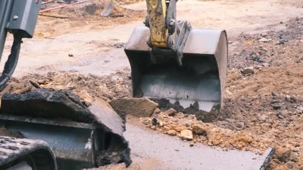 Wiadro koparki podnosi uszkodzony asfalt i ziemię. Zwolnij, 4k. — Wideo stockowe