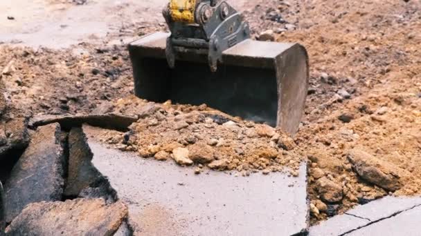 Kbelík na bagry sbírá rozbitý asfalt a hlínu. Zpomalený pohyb, 4k — Stock video