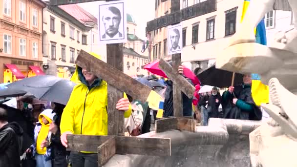ウクライナでの戦争、抗議。全体とヒトラーとしてプーチンの写真を持つ男。プーチン、プトラー。戦争に対する人々の平和的な抗議。ウクライナの国旗を持つ人々の群衆。リュブリャナ。スロベニア、 02.03.22 — ストック動画