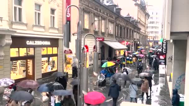 Lidé s ukrajinskými vlajkami a plakáty PUTIN MURDERER a STOP WAR procházky po ulici. Velký dav lidí. Masové demonstrace. Mírový protest. Lublaň. Slovinsko, 02.03.22 — Stock video