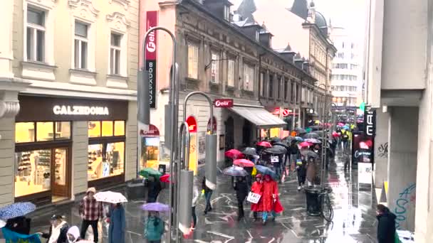 Az ukrán zászlókkal és plakátokkal rendelkező emberek átsétálnak Ljubljana utcáin a főtérre, hogy tiltakozzanak. Nagy tömegben. Tömegtüntetések. Békés tiltakozás. Ljubljanában. Szlovénia, 02.03.22 — Stock videók