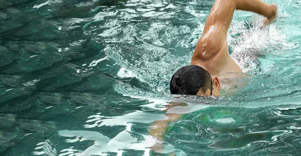 プールで這って泳いでいる男。トライアスロンフィットネス選手の水泳トレーニング。ターコイズブルーのウォーターバナーパノラマに浮かぶスイマー。スポーツとフィットネスカーディオ演習。パノラマバナー. — ストック写真