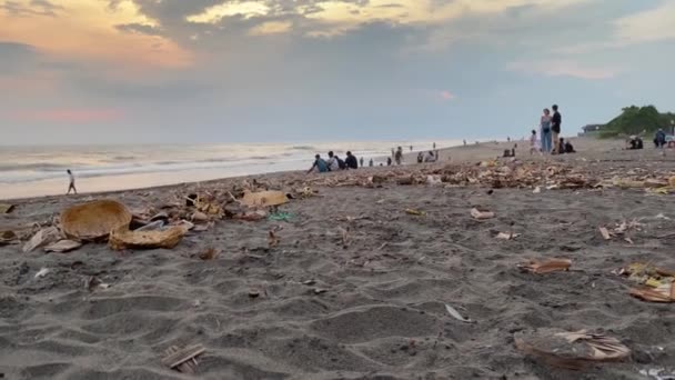 Nyepi. Vue de la plage de sable pollué après la journée de silence, Nouvel An balinais, sur la côte de l'océan Indien. Les gens marchent au coucher du soleil le long de l'océan. Bali, Indonésie, 24 avril 2022 — Video