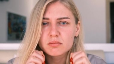 İkinci çene, obezite. 30 'lu yaşlardaki bir kadının portresi çenesinin derisini geriyor, hayal kırıklığına uğramış bir bakışla kameraya bakıyor. Yaşlanma ve görünüş sorunları. Yüz gerdirme, estetik ameliyat