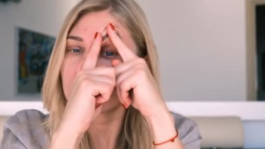 Yaşlanıyorum. Sarkık derili. Genç kadın aynaya bakarak yüz gerdirme egzersizleri yapıyor. Yüz geliştirme. Modern bakım, yüz kaslarının gevşemesi. Yüz gerdirme, estetik ameliyat.