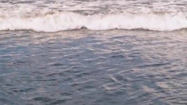 Endonezya 'nın Bali adası açıklarında güneşli bir günde köpüren okyanus dalgaları yavaş hareket ediyor. Doğanın gücü, su elementi, Hint Okyanusu. 4k