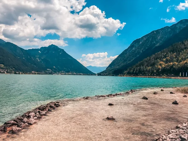 Huge mountain blue lake. Untouched wild nature of Europe. Majestic mountains covered with trees rise above the turquoise clear lake.