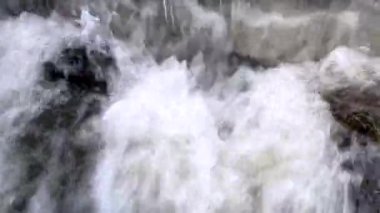 Rapid turbulent stream of water of a mountain river close-up