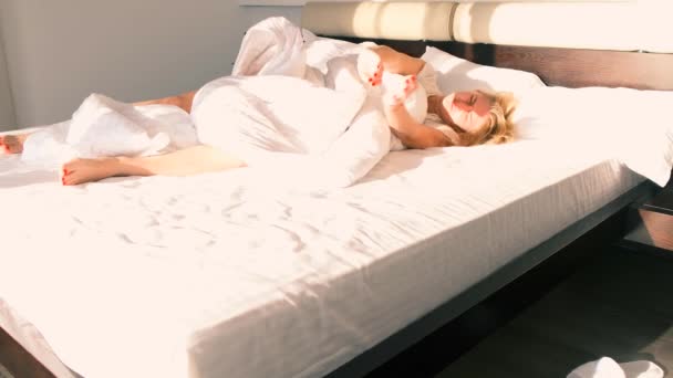 Young Woman Wakes Large Bed Sun Rays Shining Her Face — Αρχείο Βίντεο