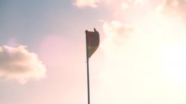 Endonezya 'nın kırmızı ve sarı bayrağı bayrak direğinde güneş ve gökyüzüne karşı rüzgarda dalgalanıyor. Ülkenin ulusal sembolü
