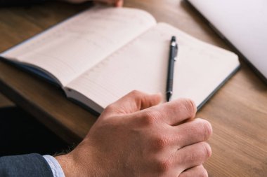 Bilgisayardan online ders alan ve deftere yazı yazan öğrenci, ev konseptinden öğrenir.