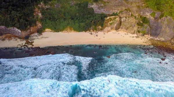 Beautiful texture of dark ocean waves of high power with white foam. Drone filming breaking surf in Indian Ocean on Nusa Penida island. Frames from birds eye view. Big wave in Bali. Capital of surfer