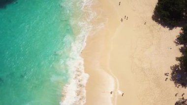 İnsansız hava aracı görüntüleri. Yukarıdan bakıldığında gün batımında turkuaz bir deniz tarafından yıkanan muhteşem bir sahil manzarası var. Kelingking Plajı, Nusa Penida, Endonezya
