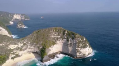 Bali, Endonezya 'daki ünlü Kelingking Sahili ve Nusa Penida kayalıklarının dramatik hava aracı görüntüleri.