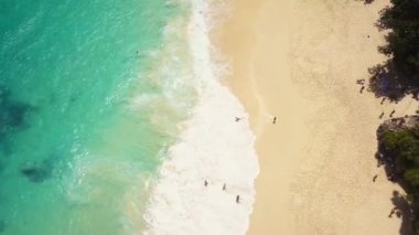 İnsansız hava aracı görüntüleri. Yukarıdan bakıldığında gün batımında turkuaz bir deniz tarafından yıkanan muhteşem bir sahil manzarası var. Kelingking Plajı, Nusa Penida, Endonezya
