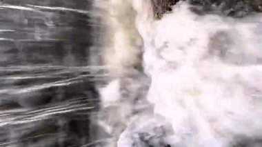 Bir dağ nehrinin hızla akan su akışının dikey 4K videosu..