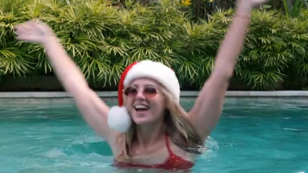 Vrolijke Blonde Vrouw Kerstmuts Zonnebril Rode Badpak Draait Viert Kerst — Stockvideo