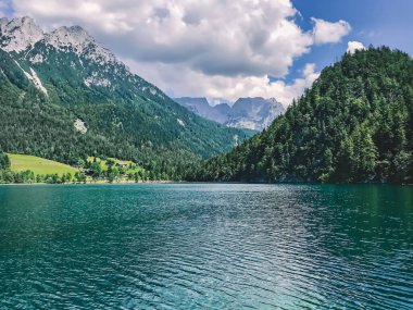 Büyük dağ mavisi göl. Avrupa 'nın el değmemiş vahşi doğası. Turkuaz berrak gölün üzerinde ağaçlarla kaplı görkemli dağlar yükseliyor..