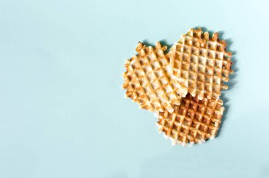 Mavi arka planda çıtır waffle 'lar. Renkli bir arkaplan kopyalama alanı üzerinde ev yapımı kekler çıtır çıtır waffle 'lar