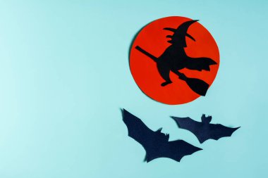 Kızıl ay 'ın arka planında yarasalarla çevrili süpürge şapkalı siyah bir cadı yazı yazılacak bir yerdir. Bir Cadılar Bayramı reklamının maketi..