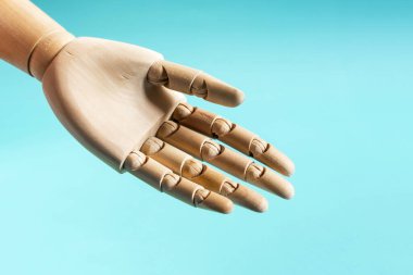 Mavi arka planda tahta bir mankenin avucu açık. Açıklık ve dürüstlük kavramı, diyalog daveti.