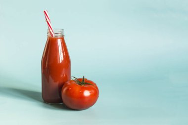 Domates suyu tüketimi kavramı. Mavi arka planda mesaj için domates suyu ve sulu domates suyu.