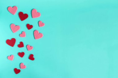 Açık mavi parlak arkaplan, kırmızı ve pembe renkli kalpler.