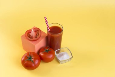 Sarı arka planda domates suyu ve domates suyu. Kırmızı tüp ve kırmızı domatesli domates suyu renkli arka plan fotokopi alanı