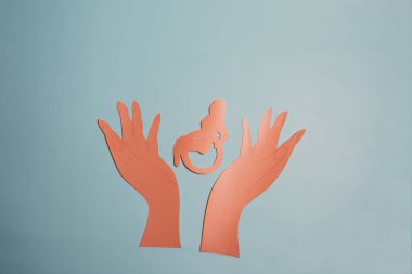 Tekerlekli sandalyedeki birinin elini tutan minimalist bir tablo. Engelliler için sosyal ve ev içi koruma