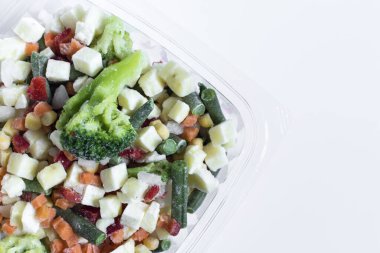 Açık arkaplanda şeffaf tabaklarda donmuş sebzeler. Hızlı dondurulmuş ürünler kavramı