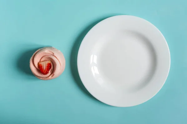 这个概念是一个通风的草莓小蛋糕 有一个海绵蛋糕蓝色背景和一个白色盘子 — 图库照片