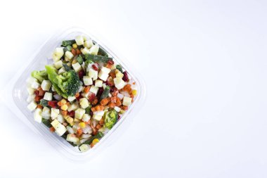 Açık arkaplanda şeffaf tabaklarda donmuş sebzeler. Hızlı dondurulmuş ürünler kavramı