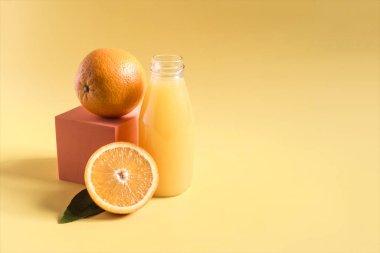 Portakal dekoru ve yeşil yapraklı şeffaf bir şişede taze portakal suyu.