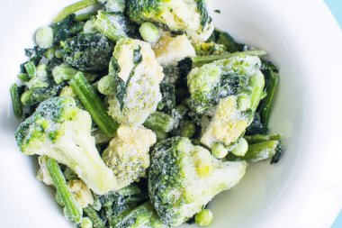 Buz kristalleriyle donuk yeşil sebzeler.