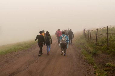 Mültecilerin soğuk bir günde sisli bir havada sınıra yürüdüğünü gördüm.