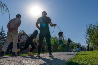 Ankara, Türkiye - 10 Ekim 2021: Tanımlanamayan gençler parkta ip atlıyor. Seçici odak.