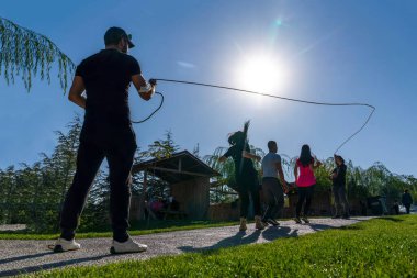 Ankara, Türkiye - 10 Ekim 2021: Tanımlanamayan gençler parkta ip atlıyor. Seçici odak.